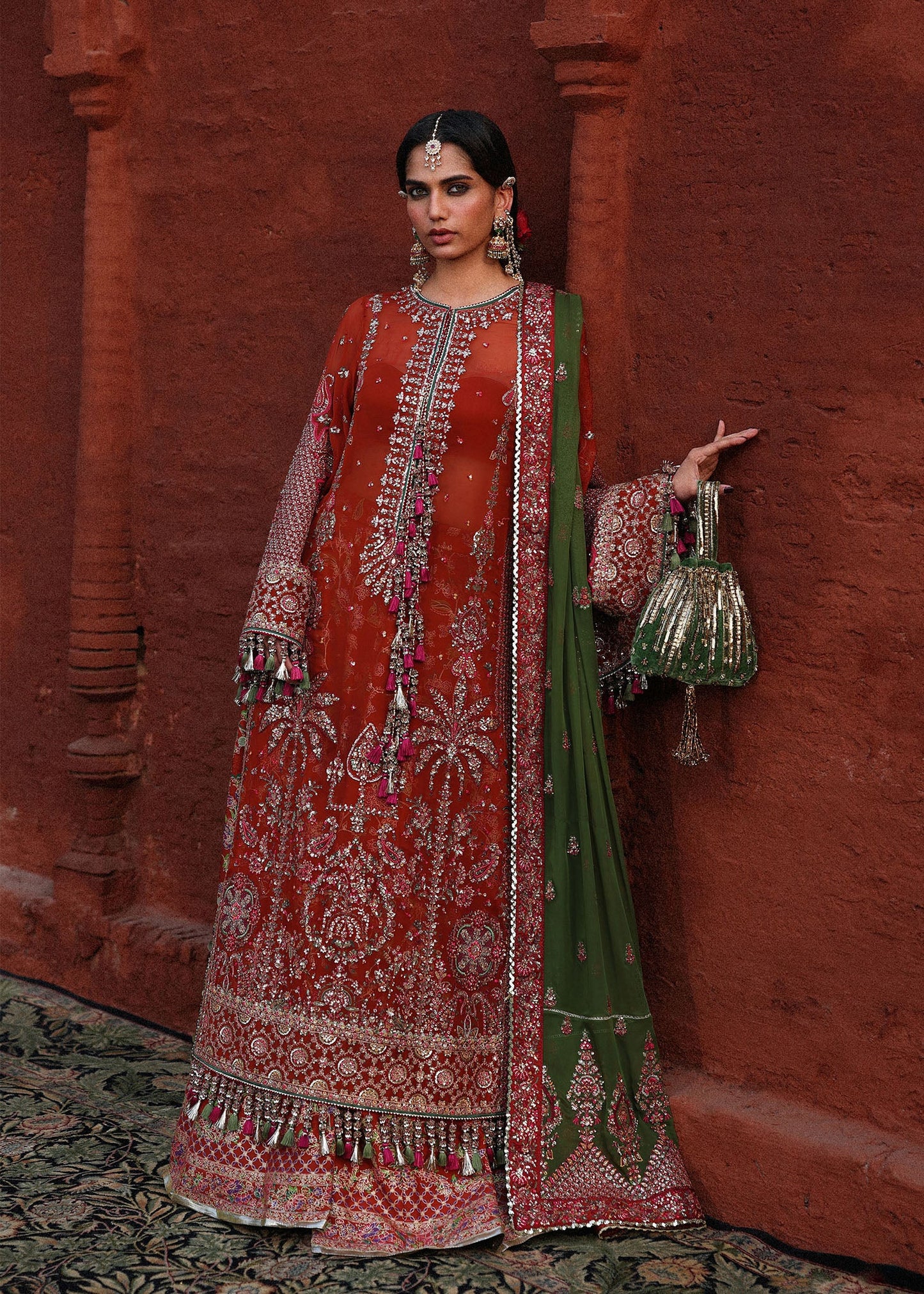 Sophisticated rust chiffon suit with intricate embroidery, bordered sleeves, Korean raw silk sharara and an embroidered chiffon dupatta with four sided borders.