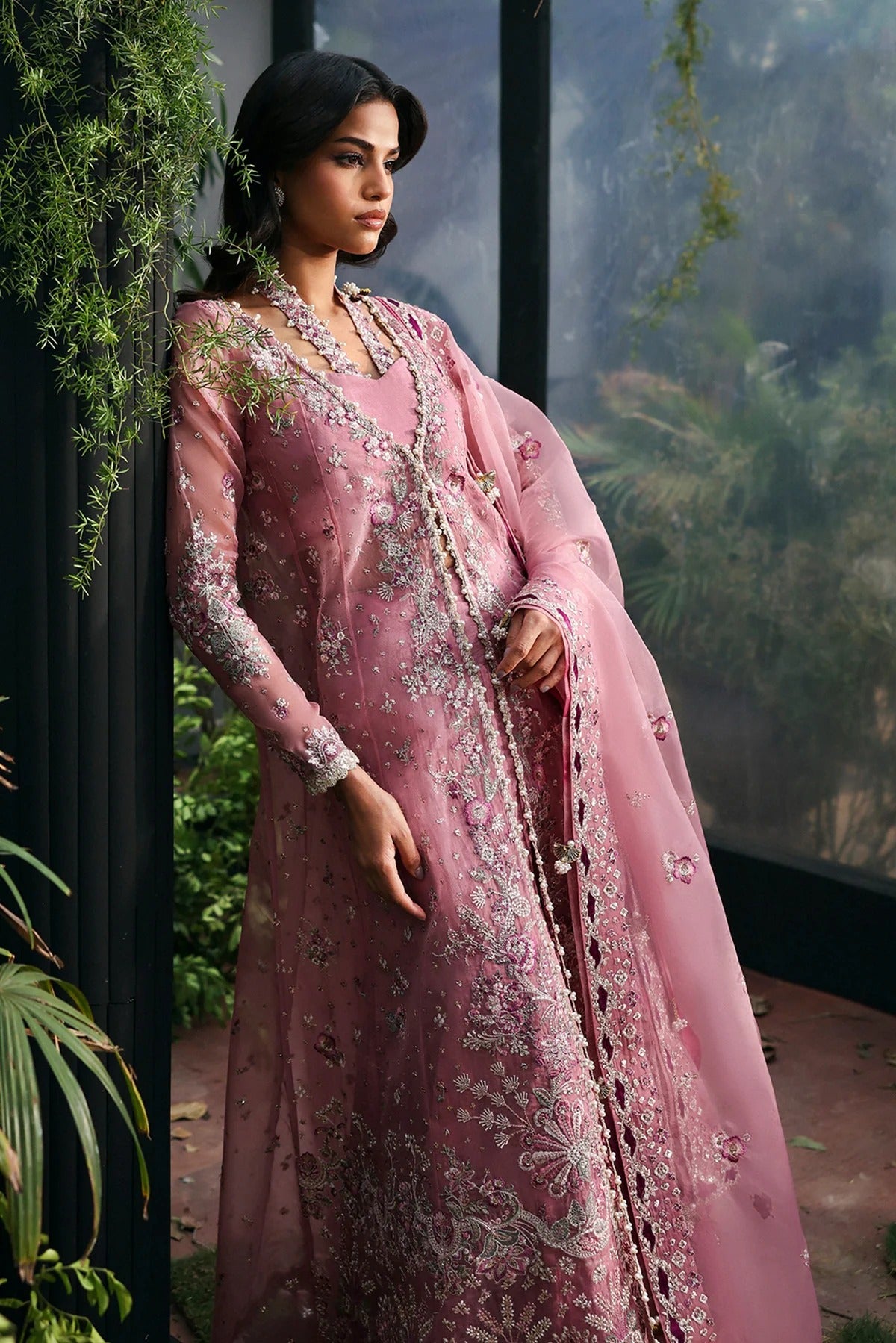 Chic pink organza dress with multi-panel embroidery, magenta silk trouser borders, and tie-dye trousers. Includes dupatta with pallu border for a vibrant look.
