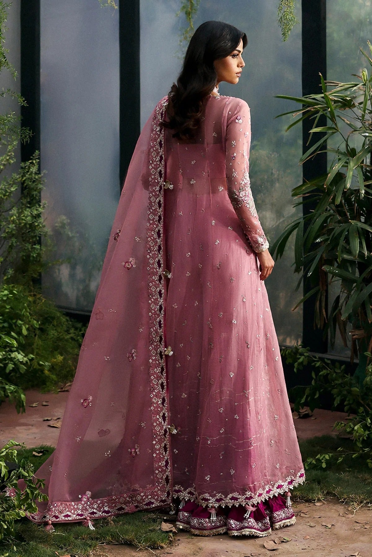 Chic pink organza dress with multi-panel embroidery, magenta silk trouser borders, and tie-dye trousers. Includes dupatta with pallu border for a vibrant look.