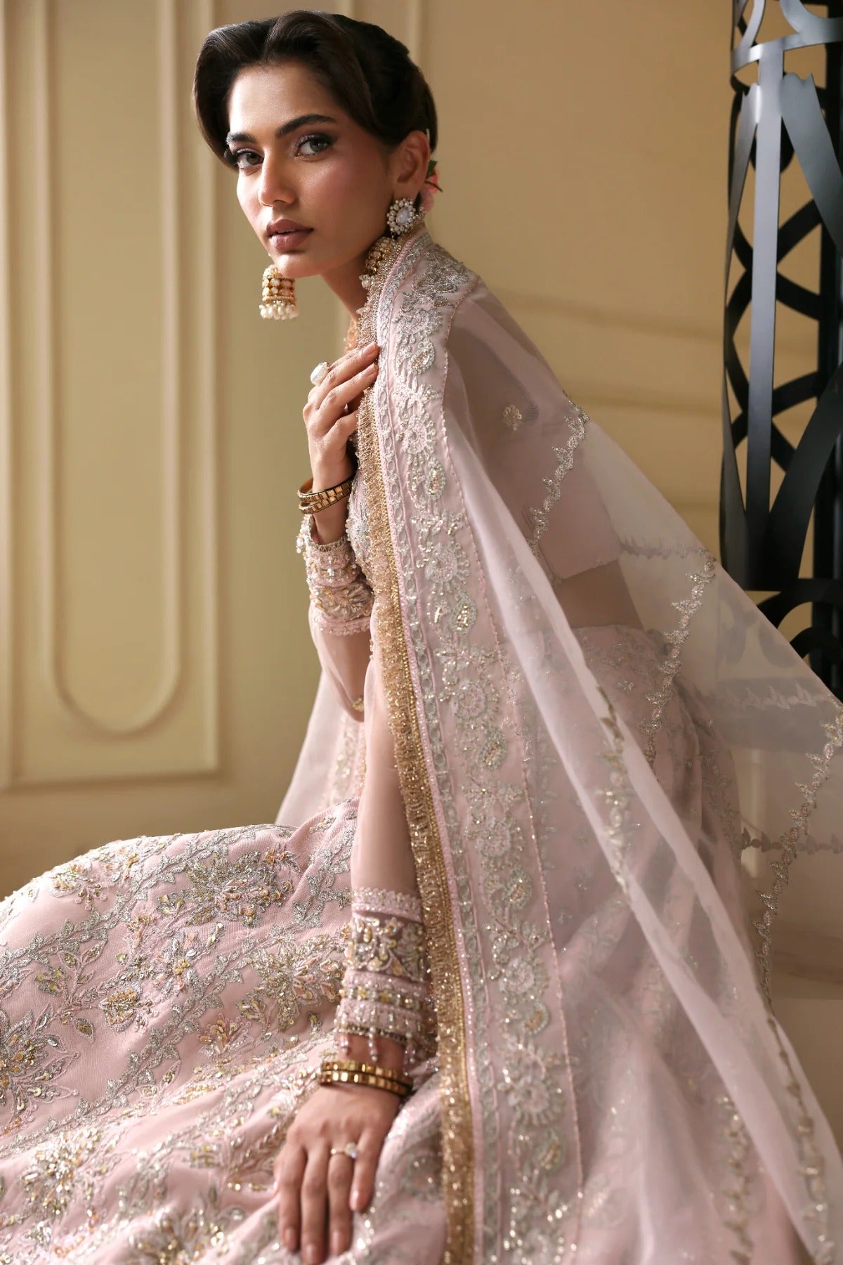 Exquisite net dress featuring hand-embellished body, sleeves, panels, and dupatta. Finished with organza kalli borders and Russian grip inner for layering.