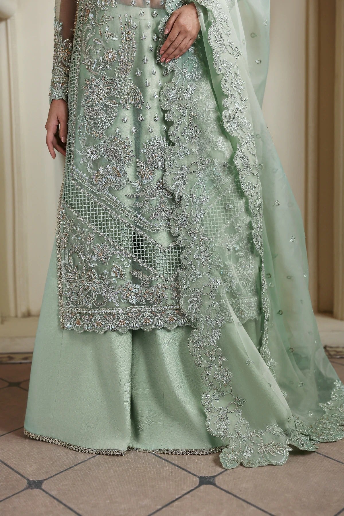 Elegant organza dress with hand-embellished front, sleeves, and borders. Paired with embroidered dupatta, Russian grip inner, and 4 yards of raw silk trouser.