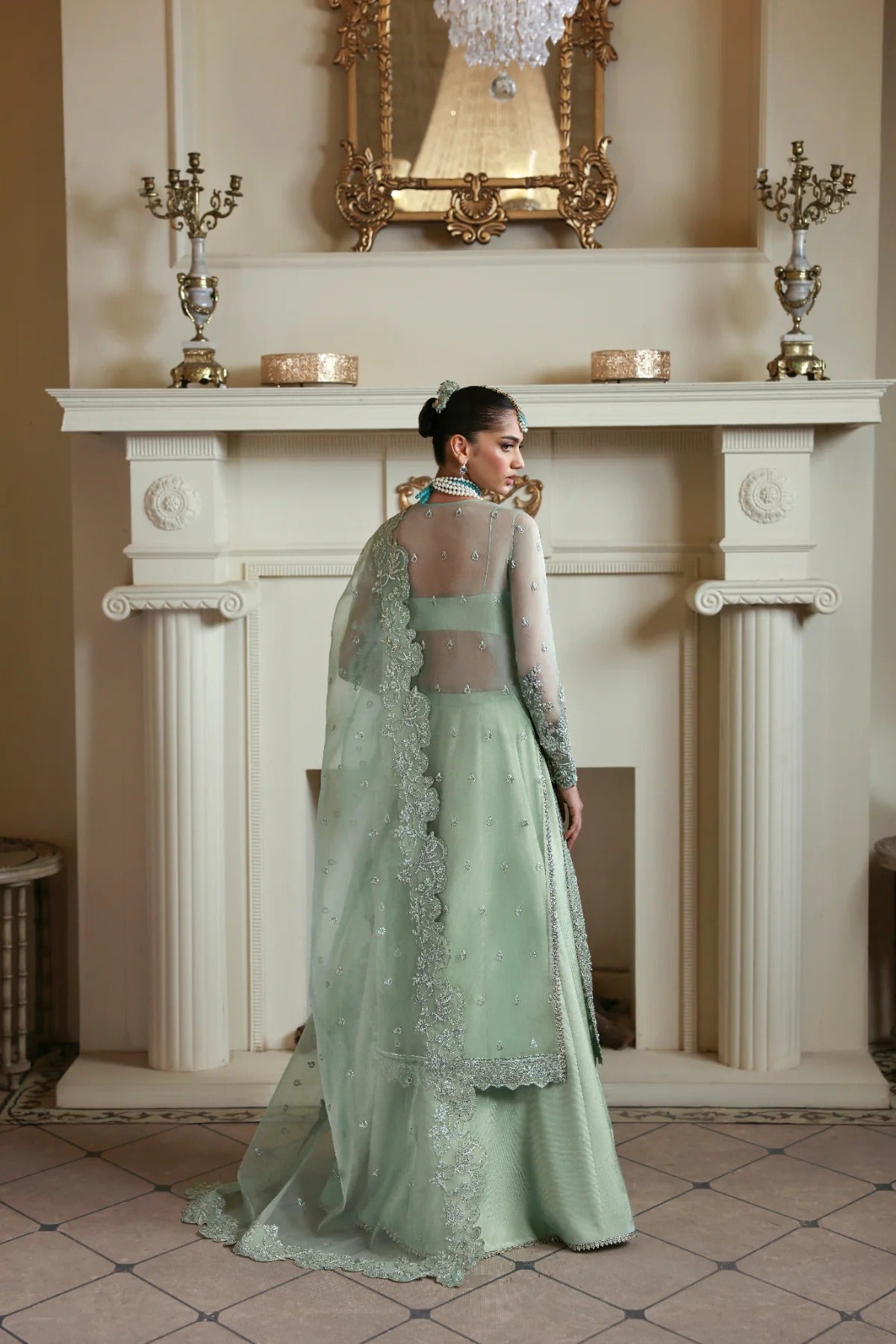 Elegant organza dress with hand-embellished front, sleeves, and borders. Paired with embroidered dupatta, Russian grip inner, and 4 yards of raw silk trouser.
