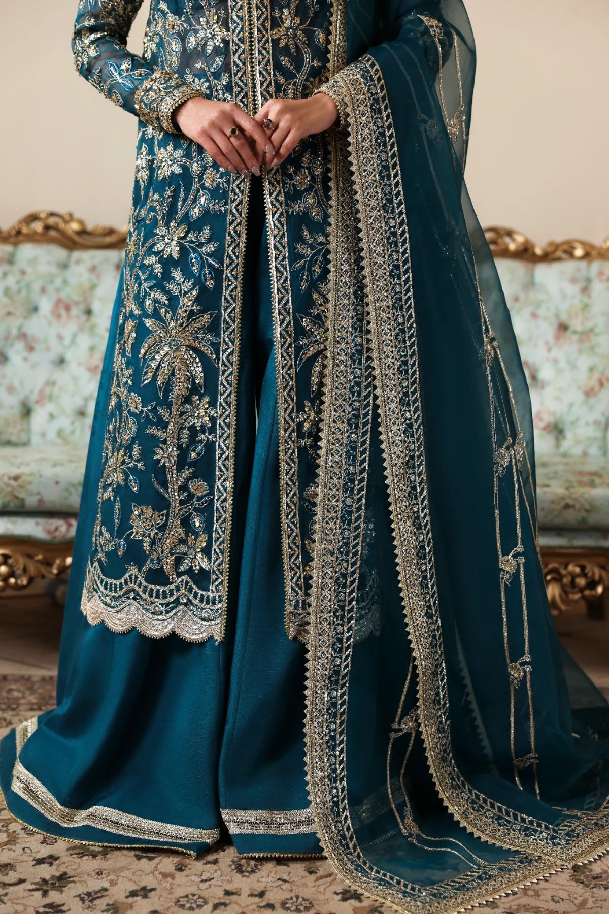 Refined organza dress with hand-embellished panels, sleeves, and borders. Includes embroidered dupatta, Russian grip inner, and raw silk trouser fabric.