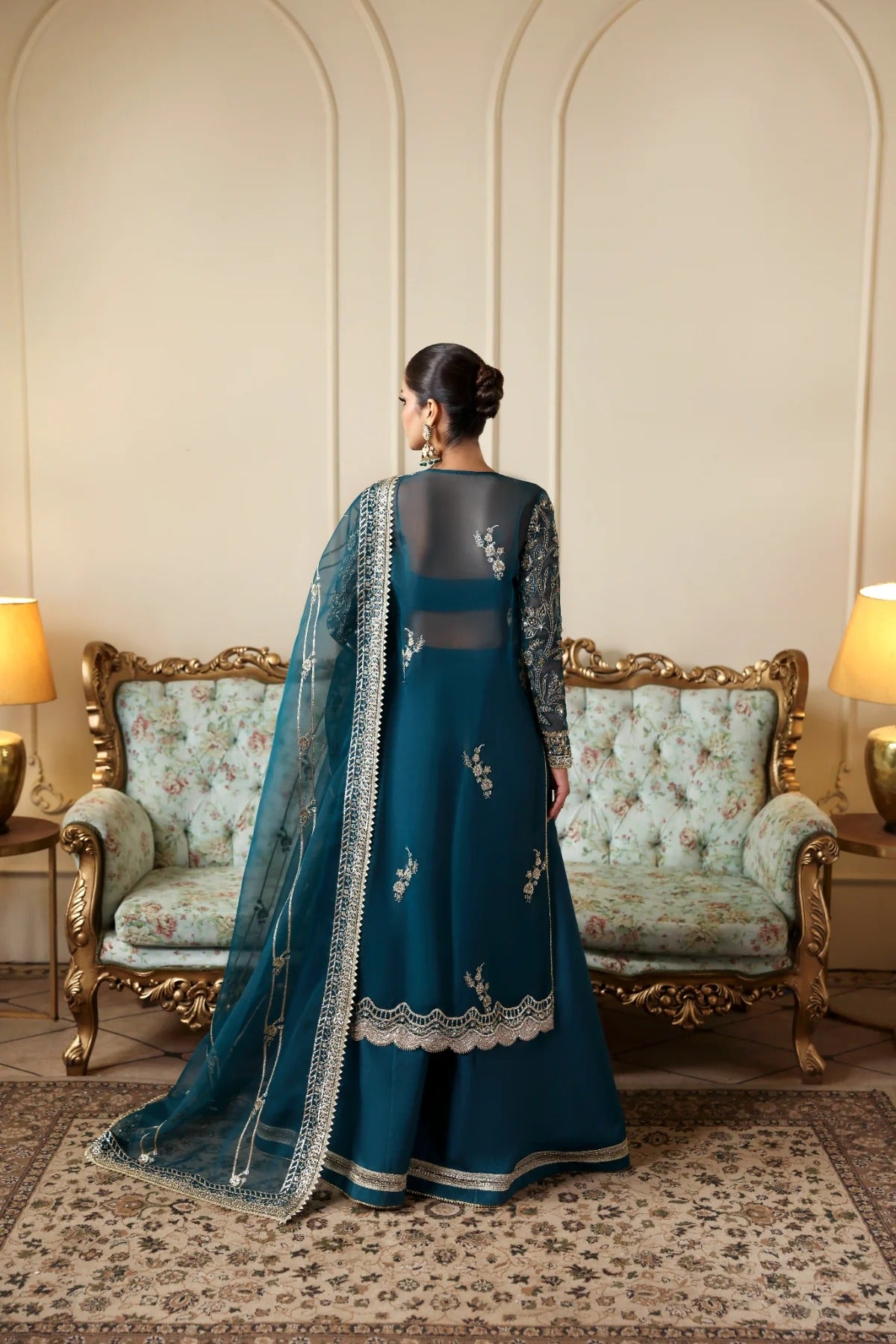 Refined organza dress with hand-embellished panels, sleeves, and borders. Includes embroidered dupatta, Russian grip inner, and raw silk trouser fabric.