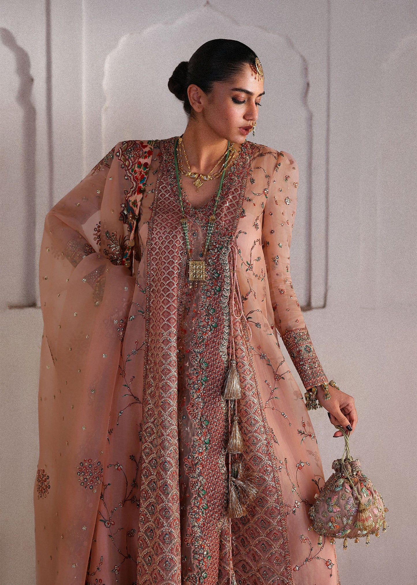 Elegant peachy pink organza angrakha pishwas with embroidered panels and sleeves, paired with Korean raw silk sharara and an organza dupatta.