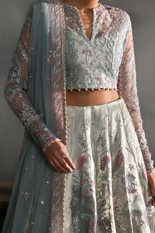 Elegant aqua net dress with intricate zari tissue embroidery in aqua and rose pink. Includes embroidered dupatta, sleeves, and dyed raw silk trouser for grace.