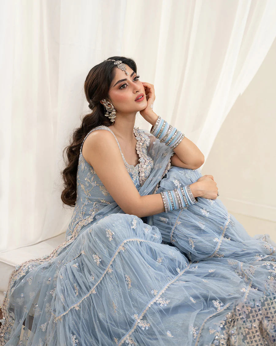 Elegant Oya gharara set in ice blue featuring intricately embroidered net shirt, gharara, and dupatta. Perfect for festive occasions and contemporary celebrations.