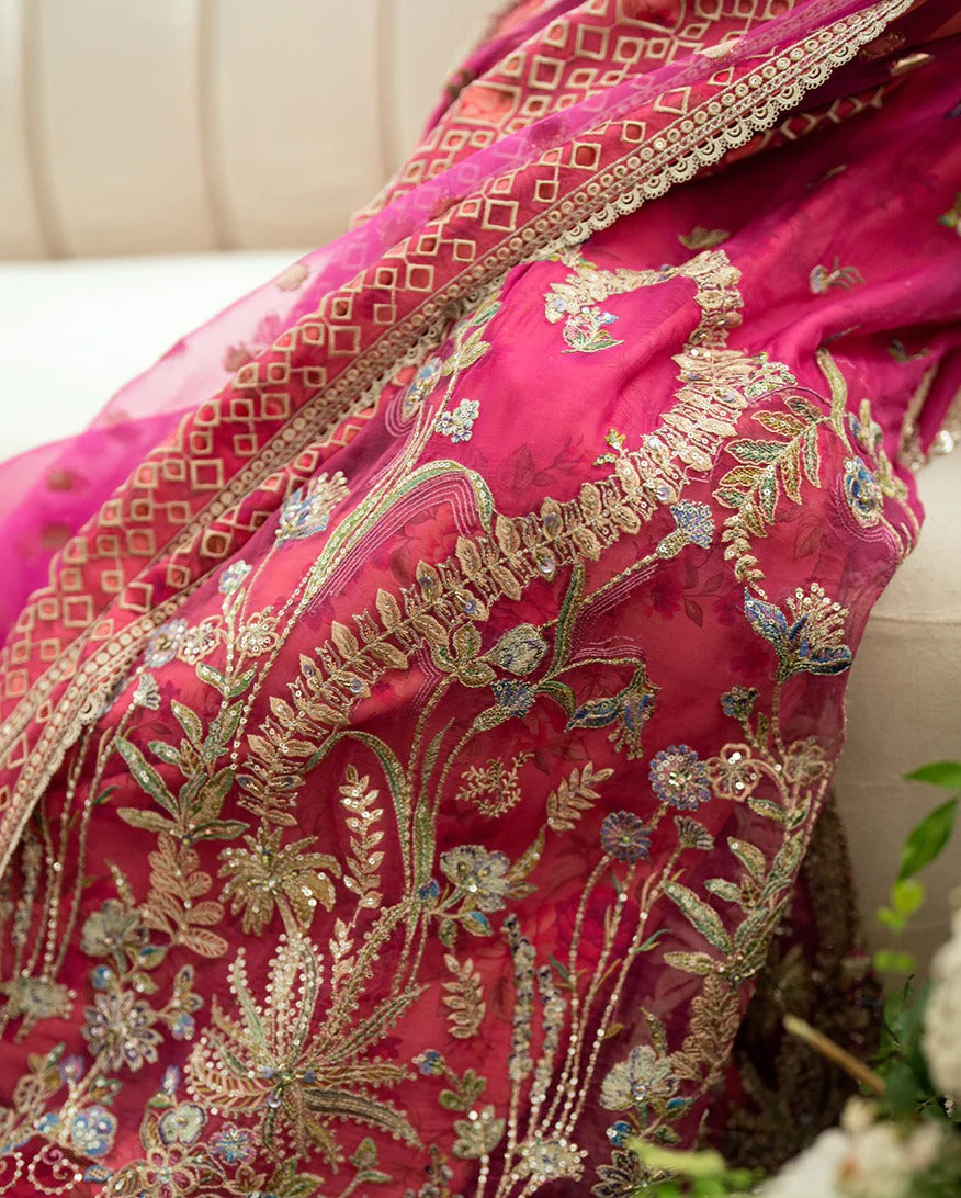 Shop this shocking pink chiffon suit with silk sleeves, lurex dupatta & raw silk trouser. Hand embellishments, sequins & tassels add a luxe festive finish!