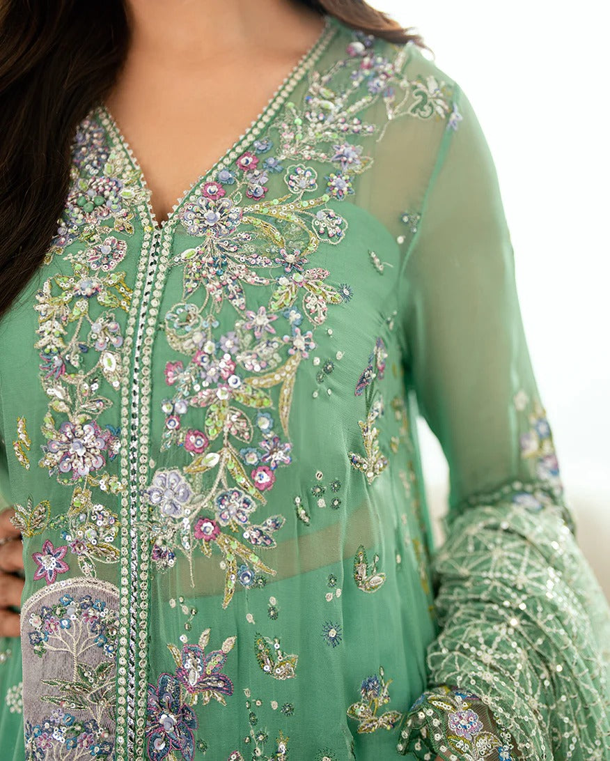 Shop this sea green chiffon suit with hand embellishments, sequinned net dupatta, raw silk trousers, and handcrafted tassels. Perfect for festive occasions!