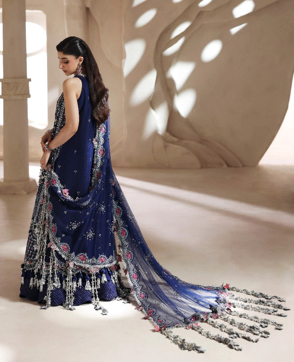 Discover elegance in this paneled net gown featuring classic shikargah motifs, shimmering sequins, scalloped hem, and an ethereal dupatta for timeless grace.