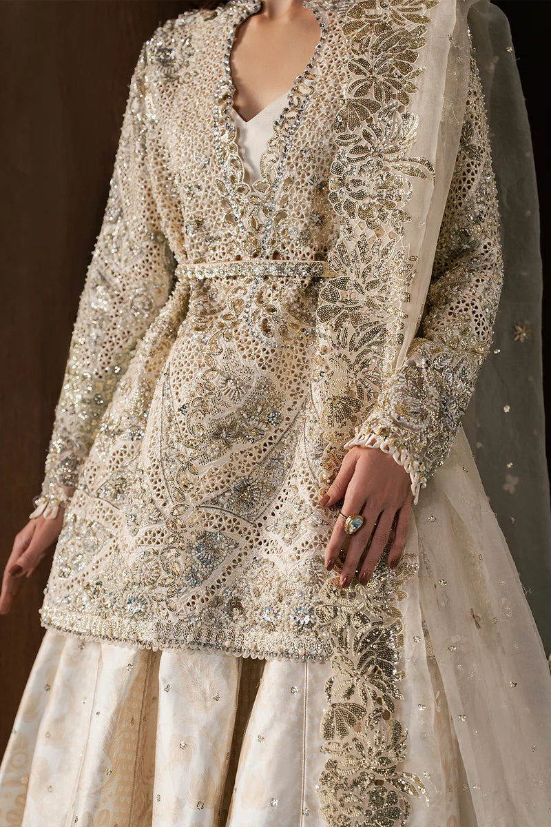 Graceful ivory wedding formal crafted in raw silk with hand-embellished embroidery, organza dupatta, lehnga borders and a timeless silhouette.