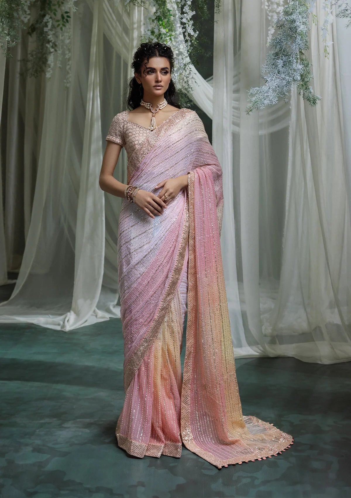 Graceful chiffon saree with printed and embroidered fall and pallu, paired with an embroidered chiffon blouse, organza borders, and a medium silk petticoat.
