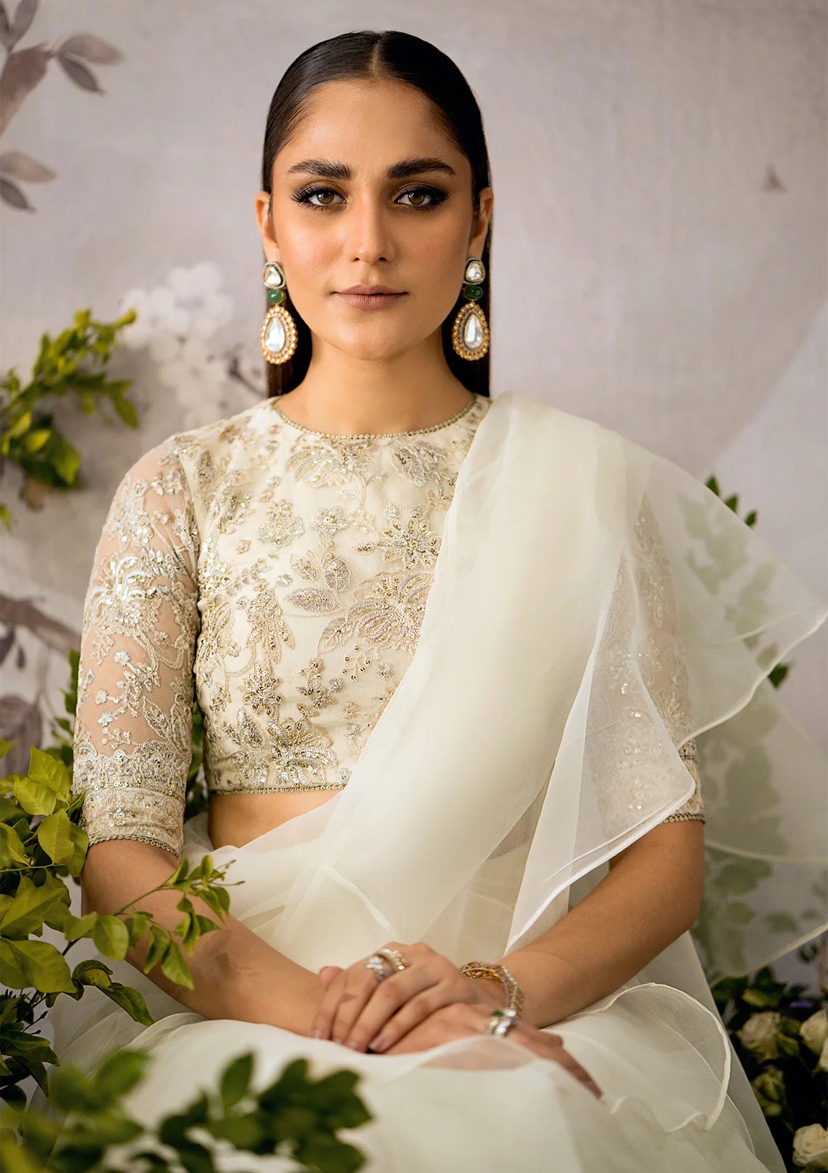 Pristine white organza saree with a dramatic ruffled hem, paired with an embroidered net blouse featuring light gold tilla, sequins, and delicate lace accents.