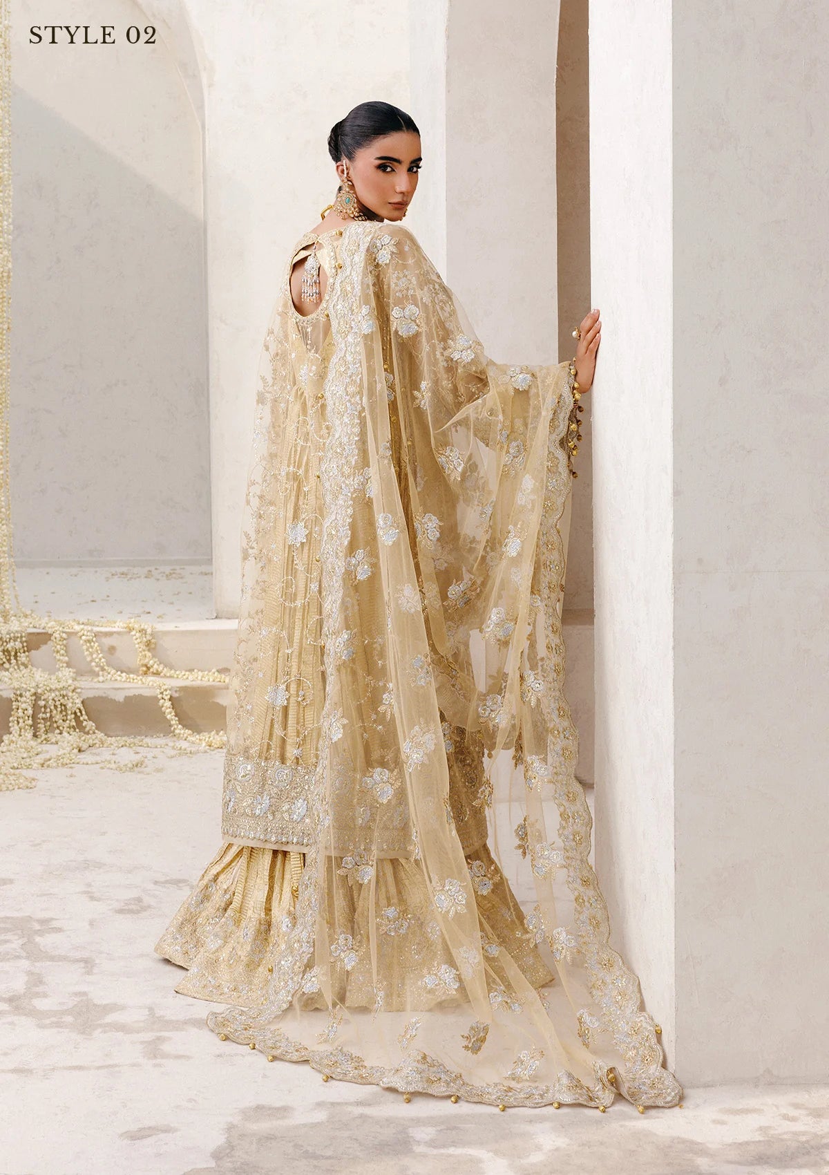 Elegant embroidered net ensemble with tissue neckline, rich borders, jamawar pants, and an embroidered net dupatta. Styled as a long shirt with farshi gharara or side-slit long shirt with crushed frock.