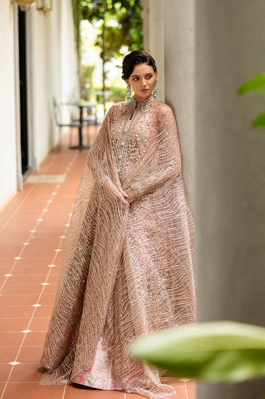 Elegant coral pink lehenga with embroidered net shirt, sequined dupatta, hand embellishments, and handmade tassels for a luxurious festive look.