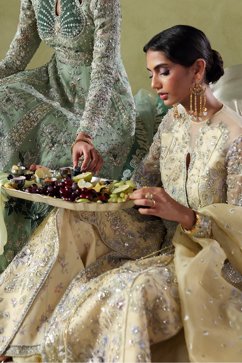 Graceful butter yellow silk suit with embroidered organza panels, embellished dupatta, and printed silk trousers. A stunning choice for festive and formal occasions.
