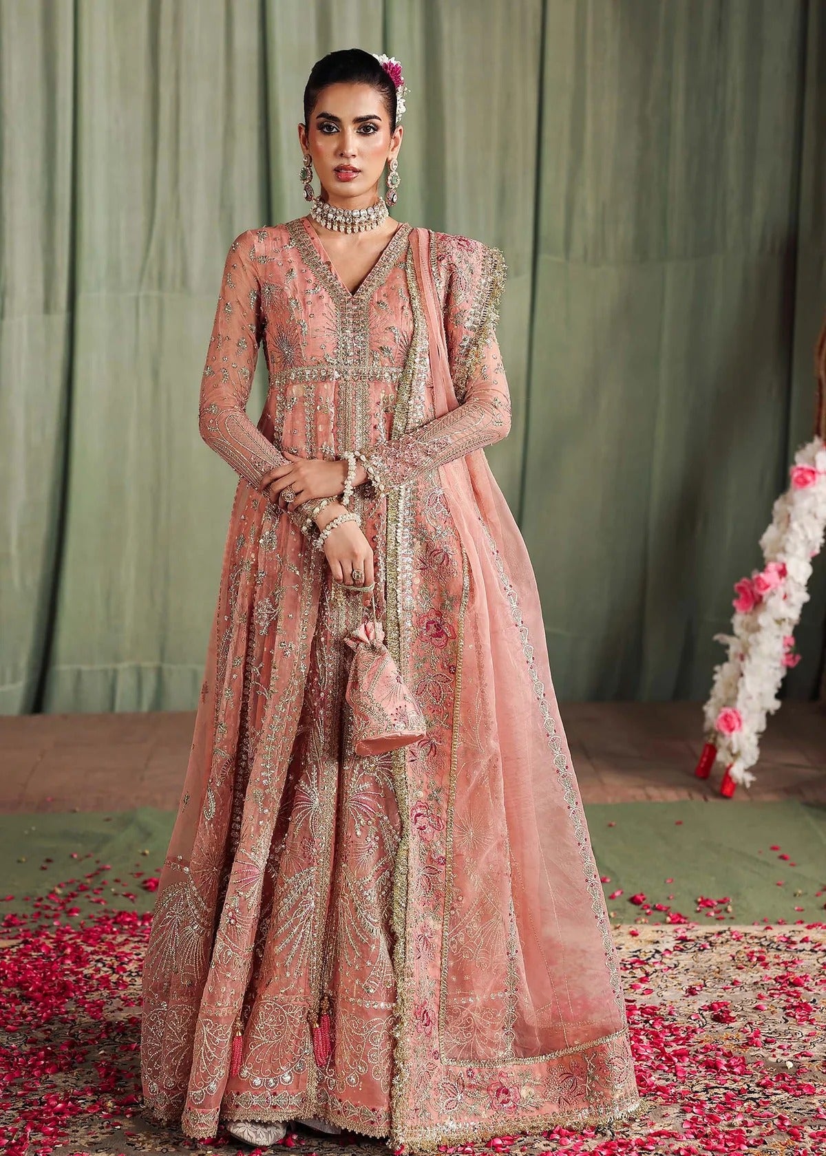 Radiate elegance in this peach organza outfit featuring intricate hand embroidery, foil printed raw silk trouser, and a beautifully embroidered dupatta.