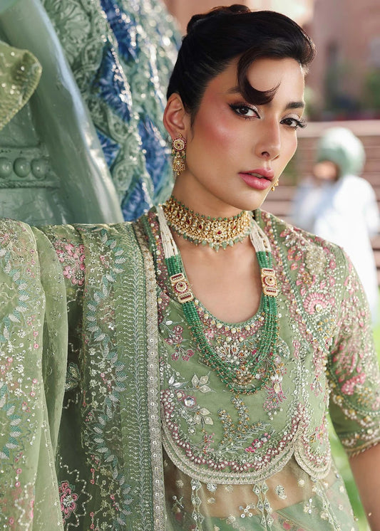 Elevate your festive look with this sage green zari organza outfit featuring delicate hand embroidery, printed raw silk trousers, and an elegant dupatta.