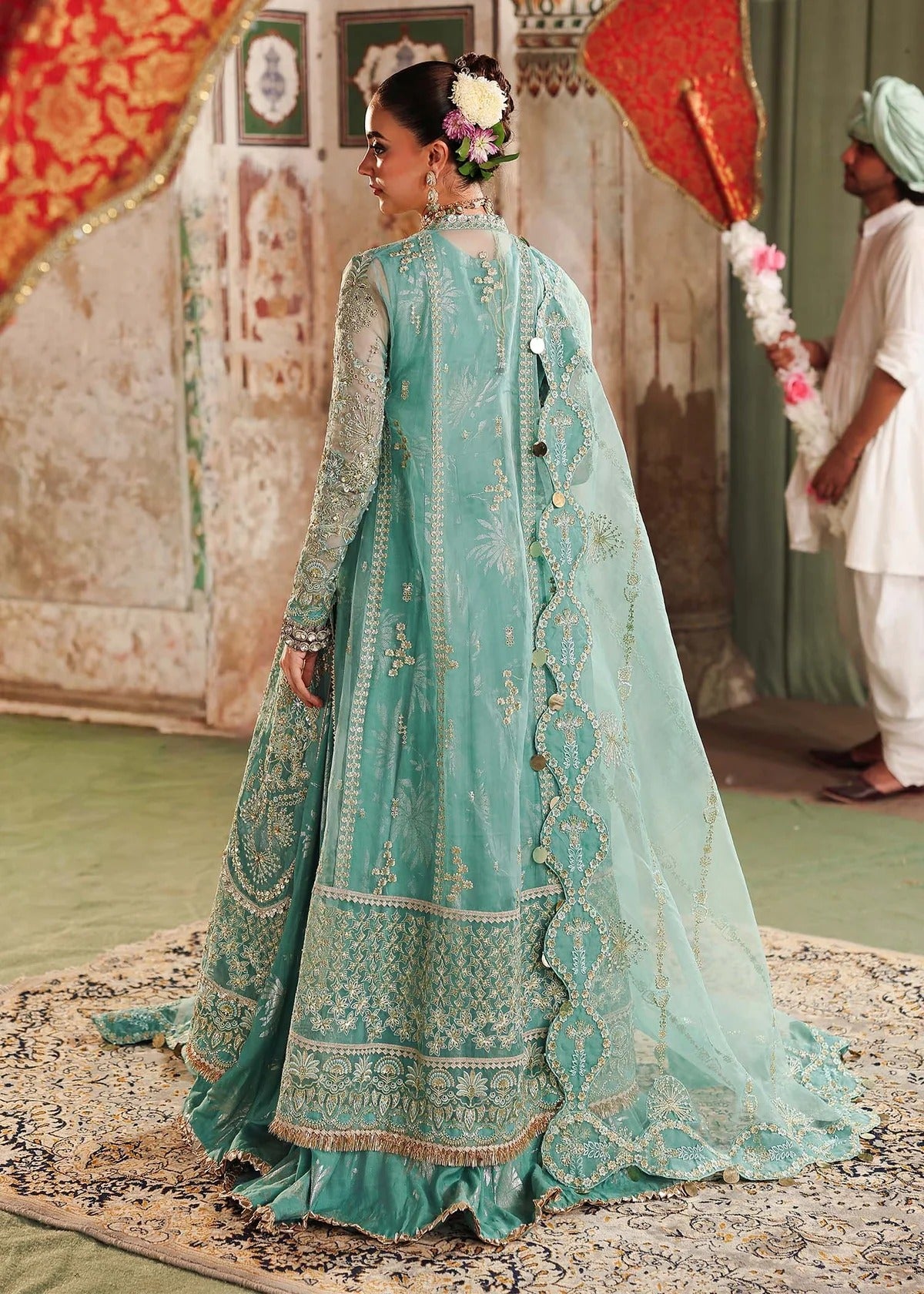 Discover timeless elegance with this turquoise organza outfit featuring intricate hand embroidery, foil-printed raw silk trouser, and embroidered dupatta.