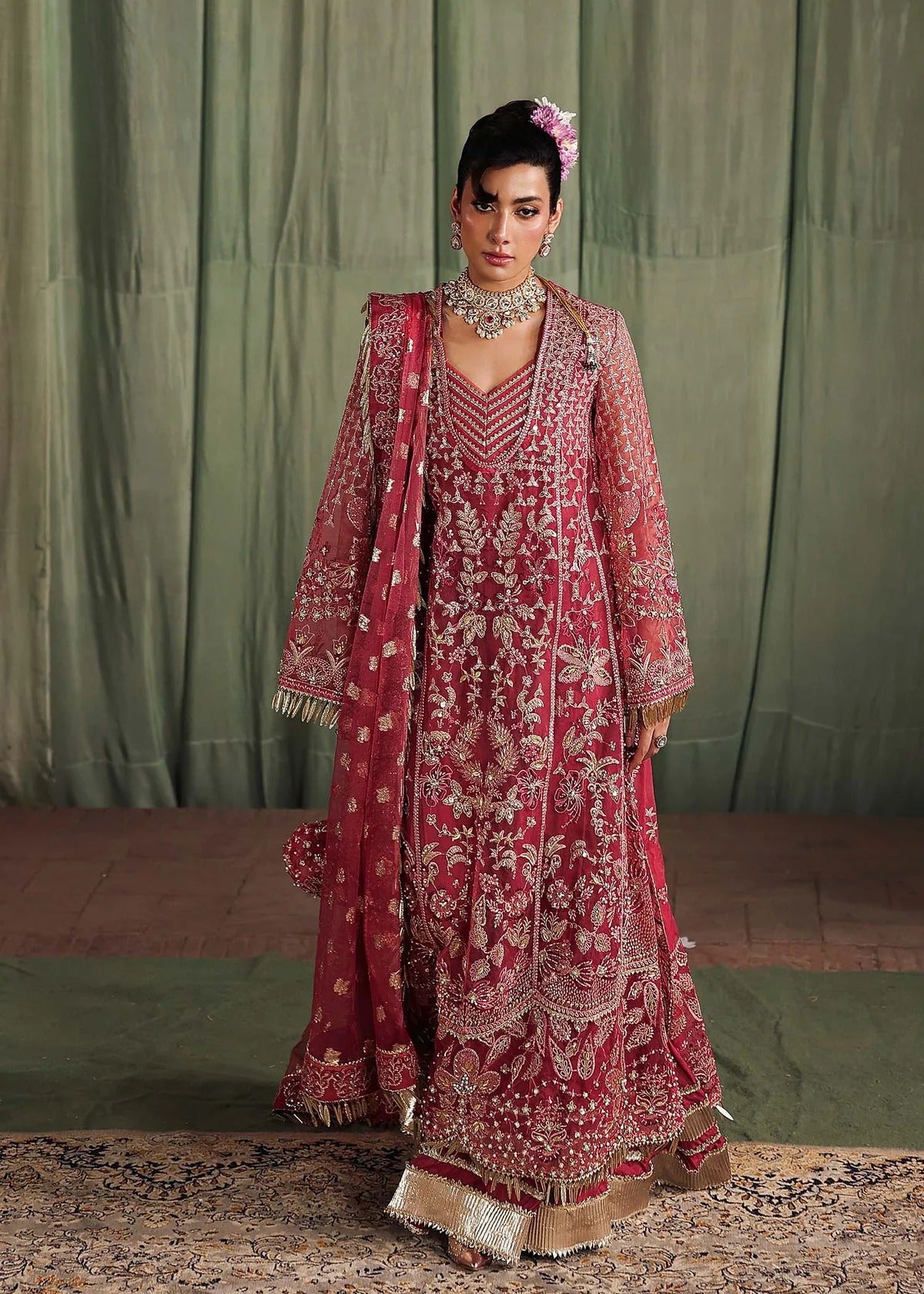 Step into elegance with this carrot pink organza ensemble featuring intricate hand embroidery, pure zari dupatta, and raw silk trouser for a refined look.