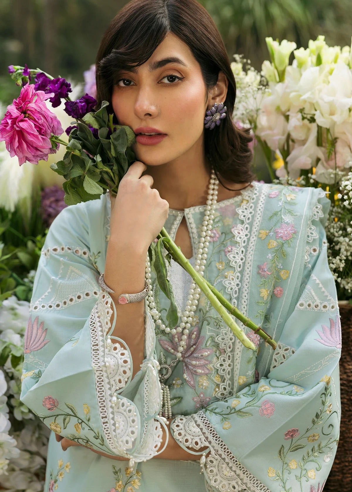 Elevate your style with this sky blue embroidered lawn suit featuring hand-work neckline, chikan-kari sleeves, net dupatta, and cotton trouser.