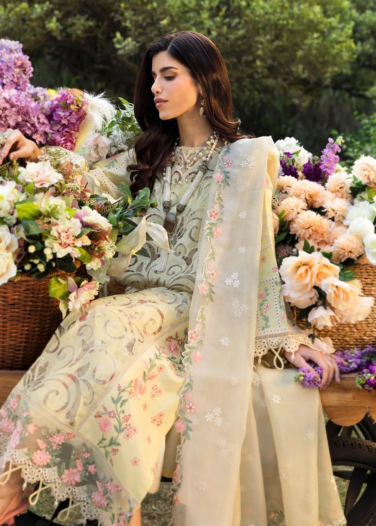 Shop this yellow embroidered lawn suit with chikan-kari sleeves, organza borders, woven net dupatta, and cotton trouser for an elegant summer look.