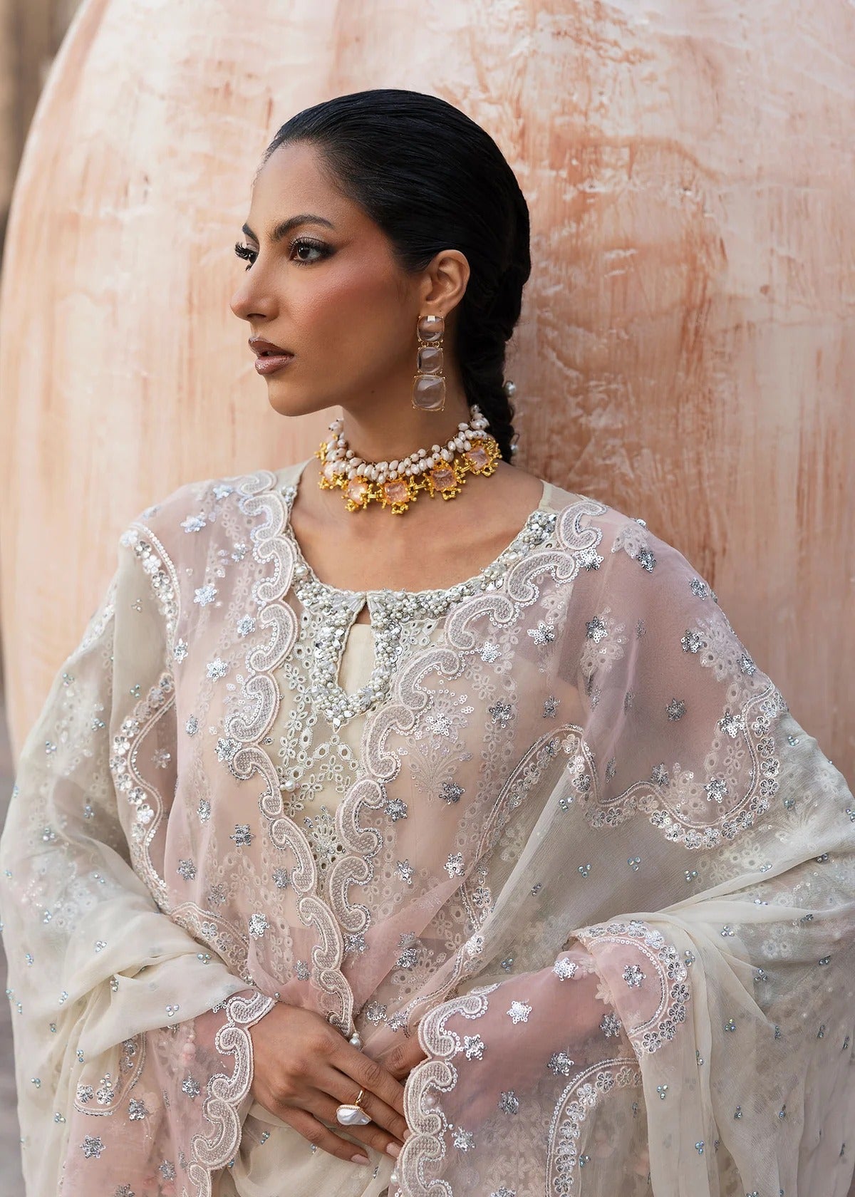 Elegant chiffon embroidered suit with hand embellishment, cutwork borders, diamante & mukesh dupatta, and raw silk trouser perfect for festive wear.