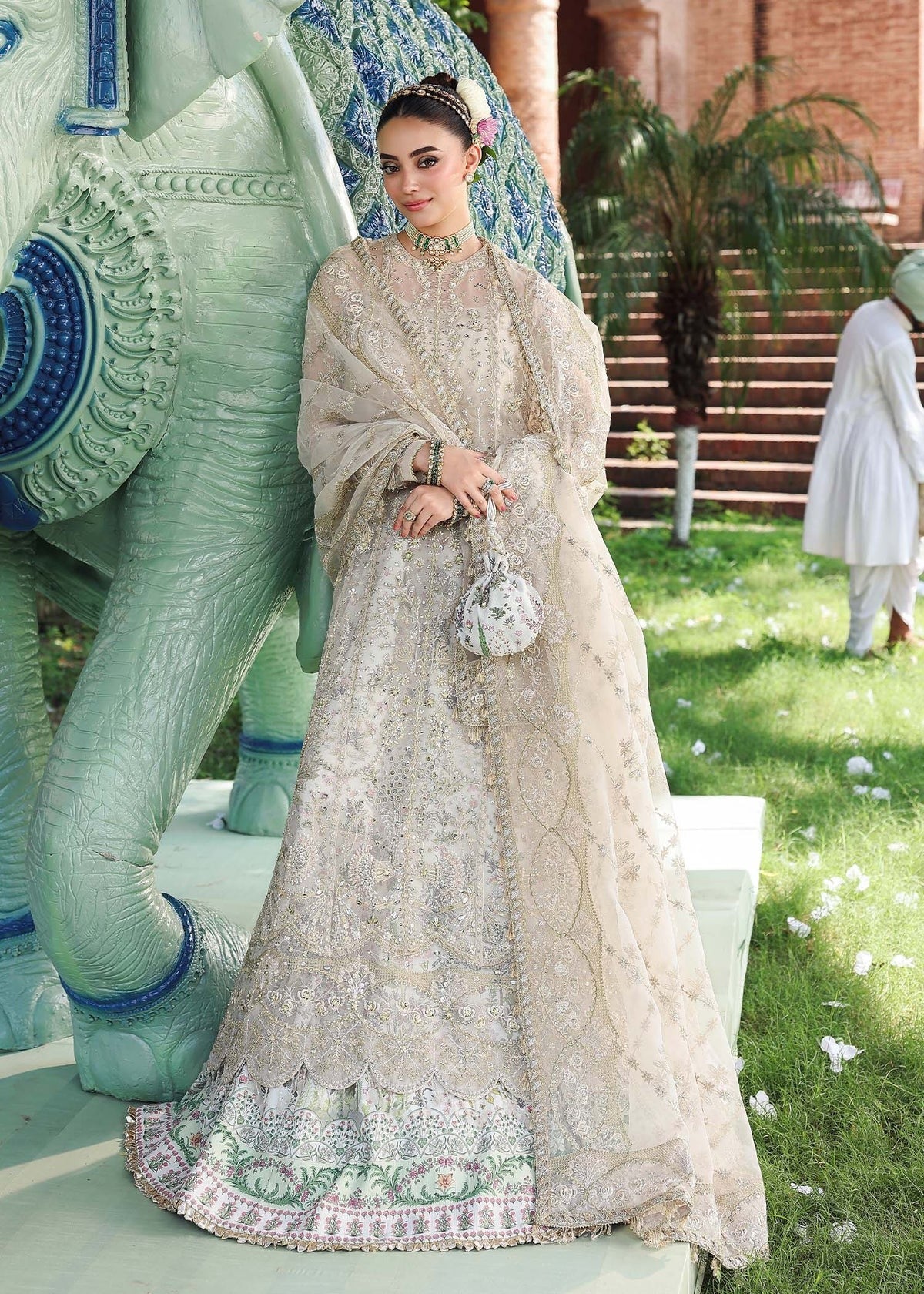 Elevate your look with this dusty white organza outfit featuring intricate hand embroidery, printed raw silk trouser, and elegant embroidered dupatta.