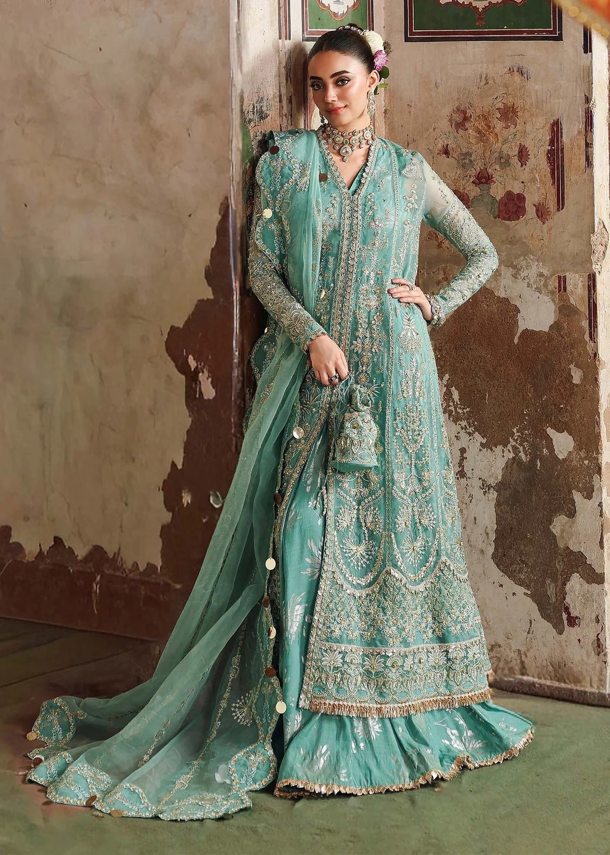 Discover timeless elegance with this turquoise organza outfit featuring intricate hand embroidery, foil-printed raw silk trouser, and embroidered dupatta.