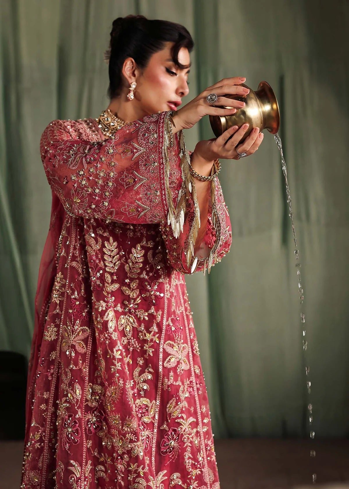 Step into elegance with this carrot pink organza ensemble featuring intricate hand embroidery, pure zari dupatta, and raw silk trouser for a refined look.