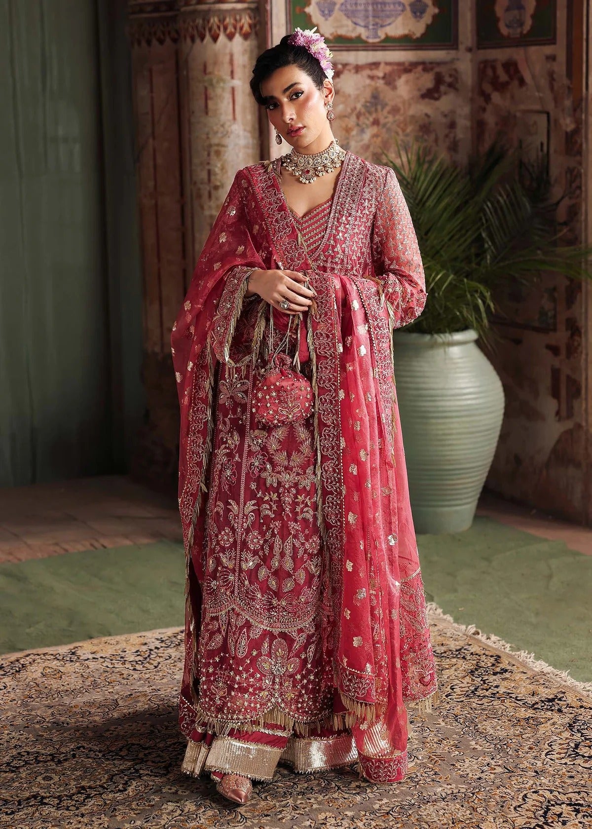 Step into elegance with this carrot pink organza ensemble featuring intricate hand embroidery, pure zari dupatta, and raw silk trouser for a refined look.