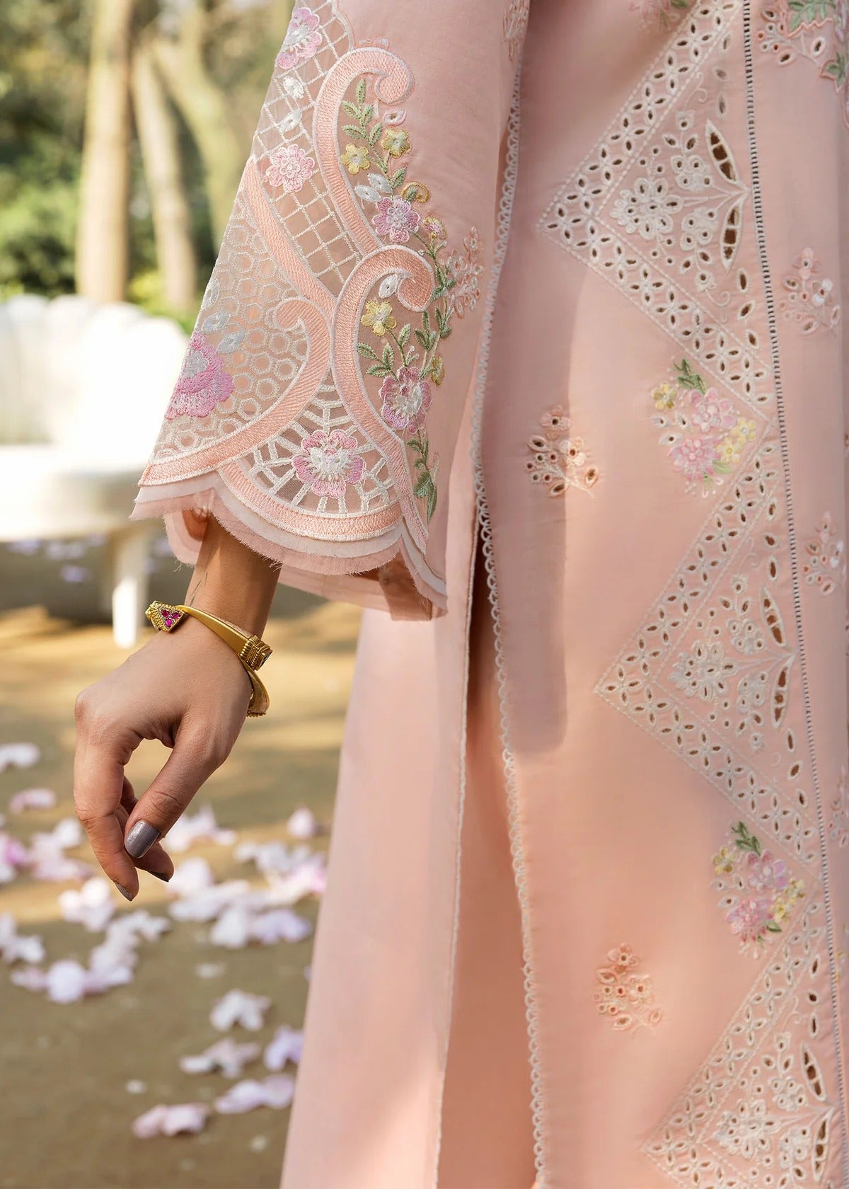 Grace your look with this peach embroidered lawn suit featuring chikan-kari panels, hand-work neckline, net dupatta, and cotton trouser.