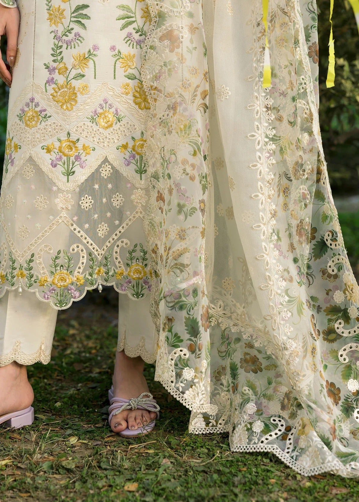 Look elegant in this ivory embroidered lawn suit with chikan-kari panels, hand-work neckline, woven net dupatta, and cotton trouser for a timeless style.