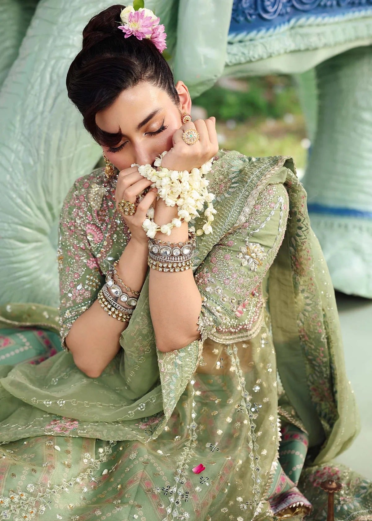 Elevate your festive look with this sage green zari organza outfit featuring delicate hand embroidery, printed raw silk trousers, and an elegant dupatta.
