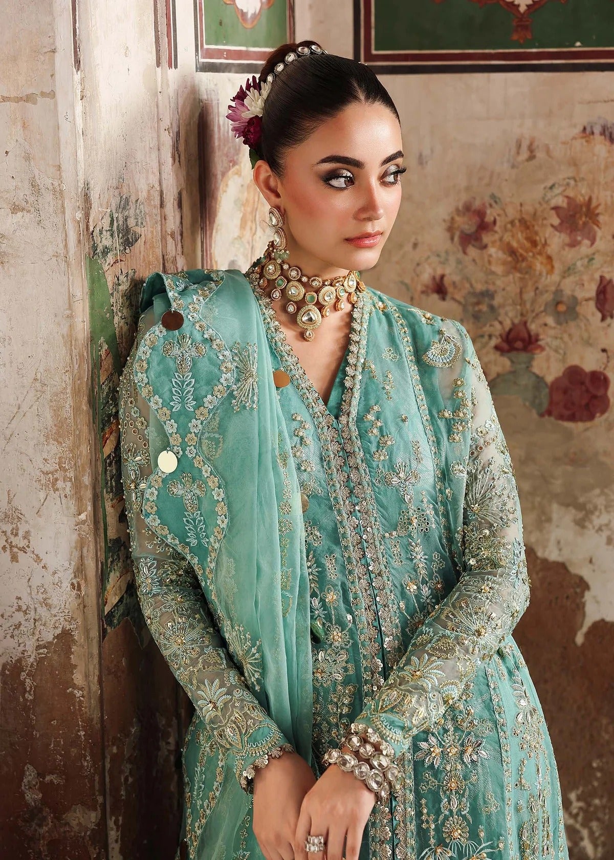 Discover timeless elegance with this turquoise organza outfit featuring intricate hand embroidery, foil-printed raw silk trouser, and embroidered dupatta.