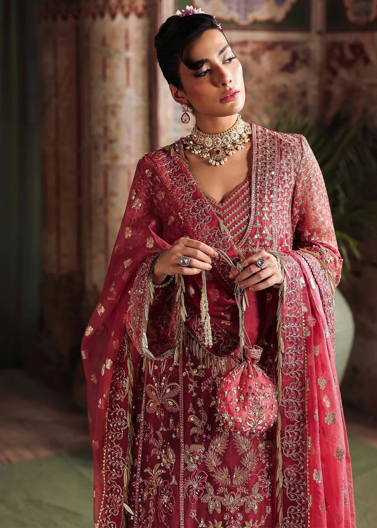 Step into elegance with this carrot pink organza ensemble featuring intricate hand embroidery, pure zari dupatta, and raw silk trouser for a refined look.