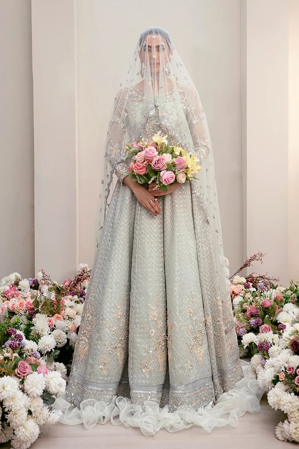 Elegant organza embroidered suit with hand-embellished bodice, cutwork panels, detailed borders, dupatta, and premium raw silk trouser fabric.