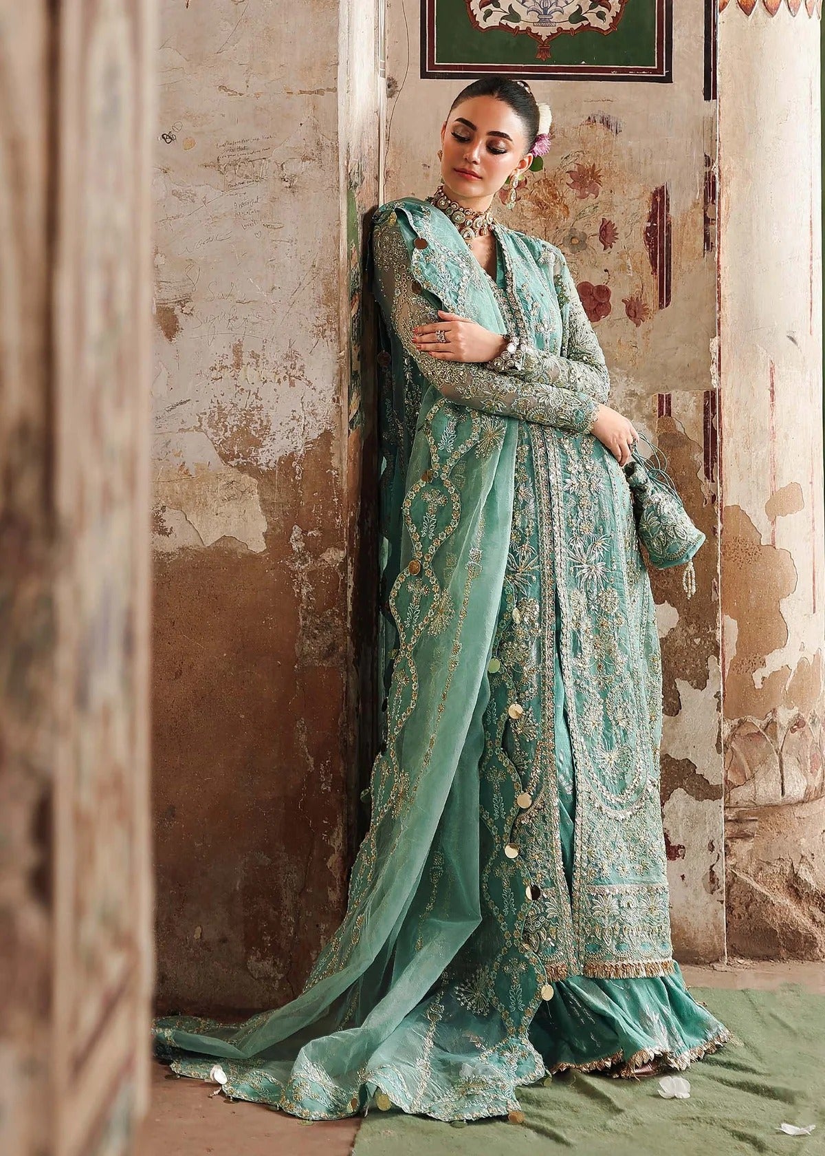 Discover timeless elegance with this turquoise organza outfit featuring intricate hand embroidery, foil-printed raw silk trouser, and embroidered dupatta.