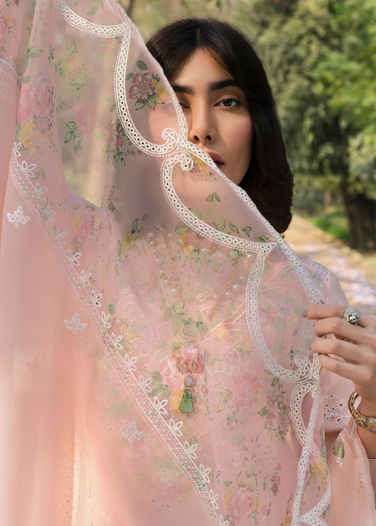 Grace your look with this peach embroidered lawn suit featuring chikan-kari panels, hand-work neckline, net dupatta, and cotton trouser.
