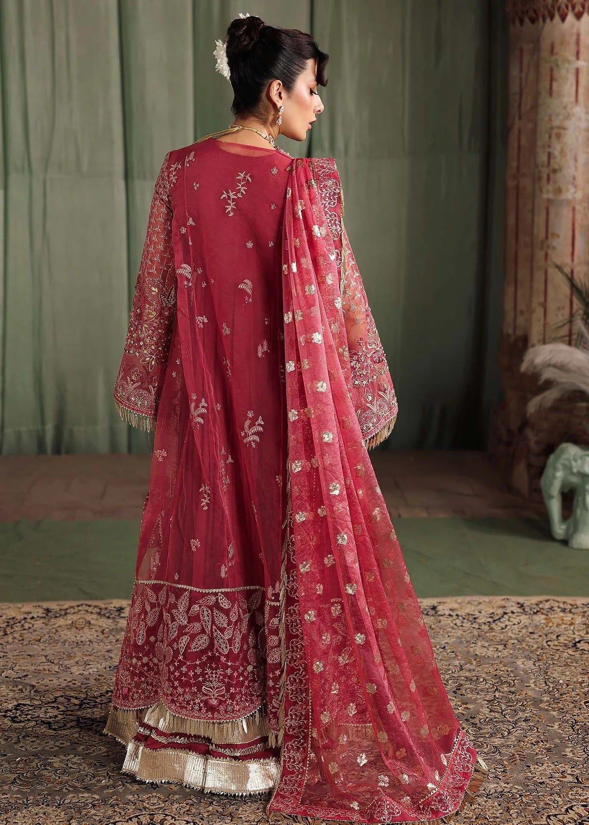 Step into elegance with this carrot pink organza ensemble featuring intricate hand embroidery, pure zari dupatta, and raw silk trouser for a refined look.
