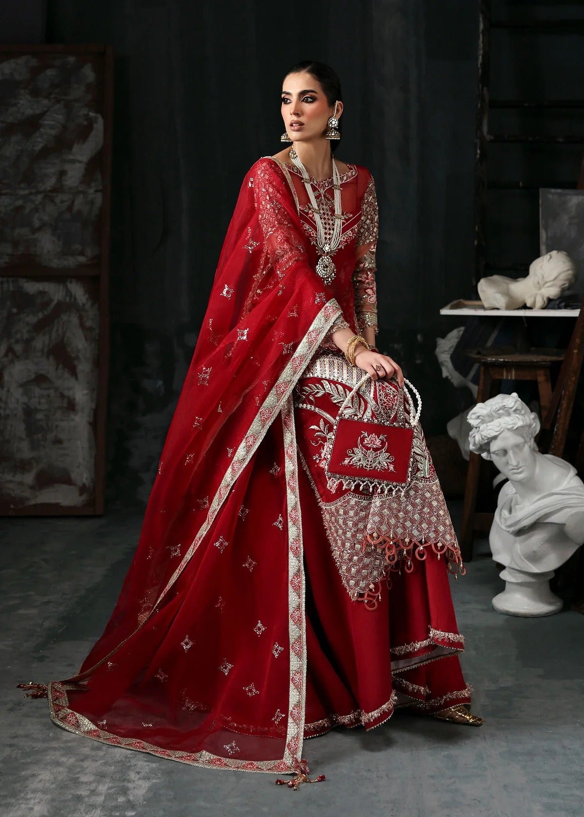 Stunning red organza dress with cutwork neckline, embroidered panels, dupatta & raw silk trouser. Available stitched/unstitch with custom sizing.