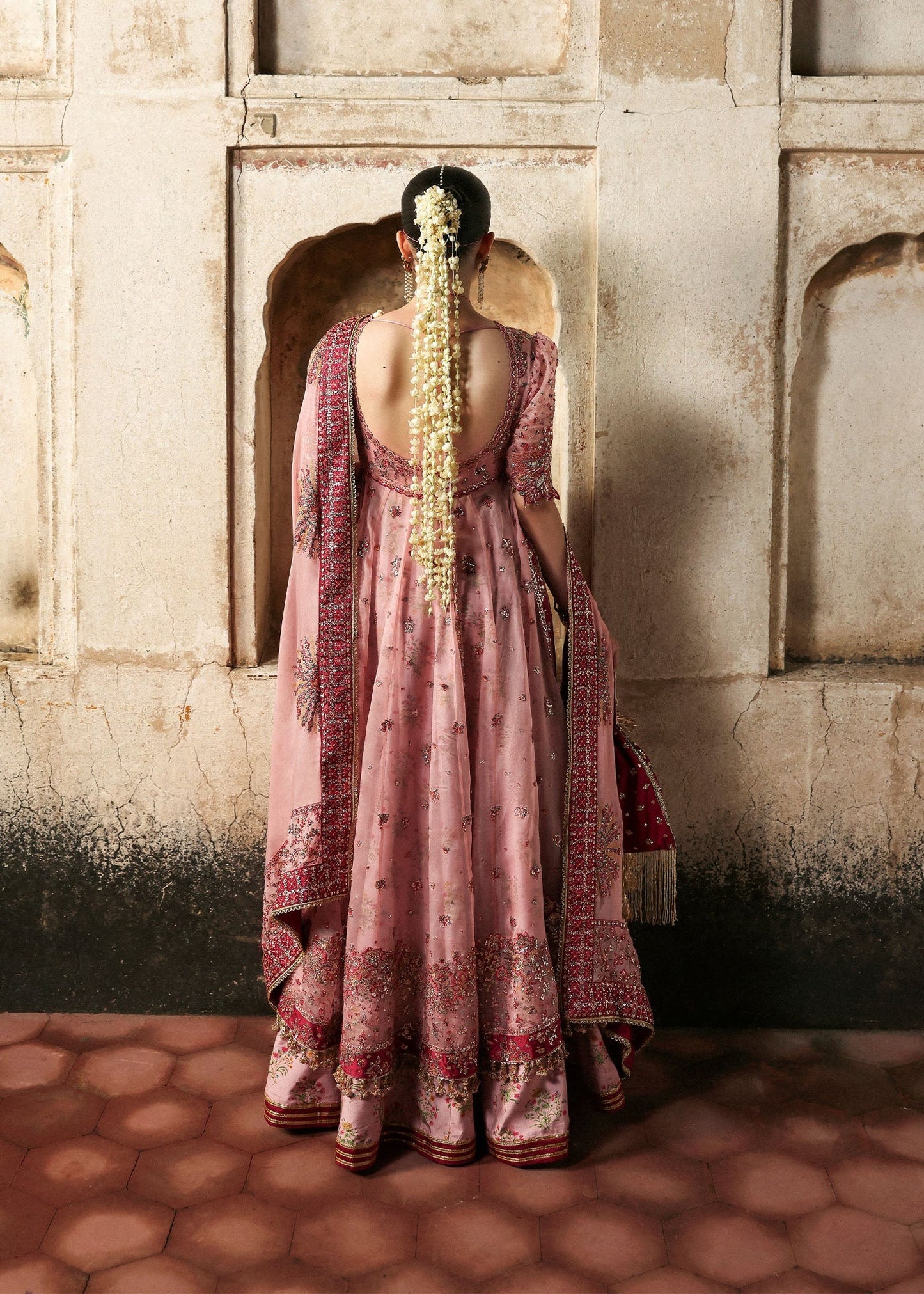 Chic rose pink organza pishwas with embroidered panels, silk lehnga, and chiffon dupatta. Unstitched festive outfit blending elegance with modern charm.