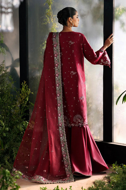 Striking cherry raw silk suit with embroidered panels, green organza dupatta border, and matching trouser for a bold festive look.