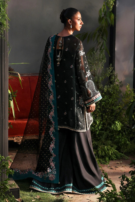 Stunning black khaadi net suit with embroidered panels, green & pink borders, block-printed organza dupatta, and raw silk trouser.