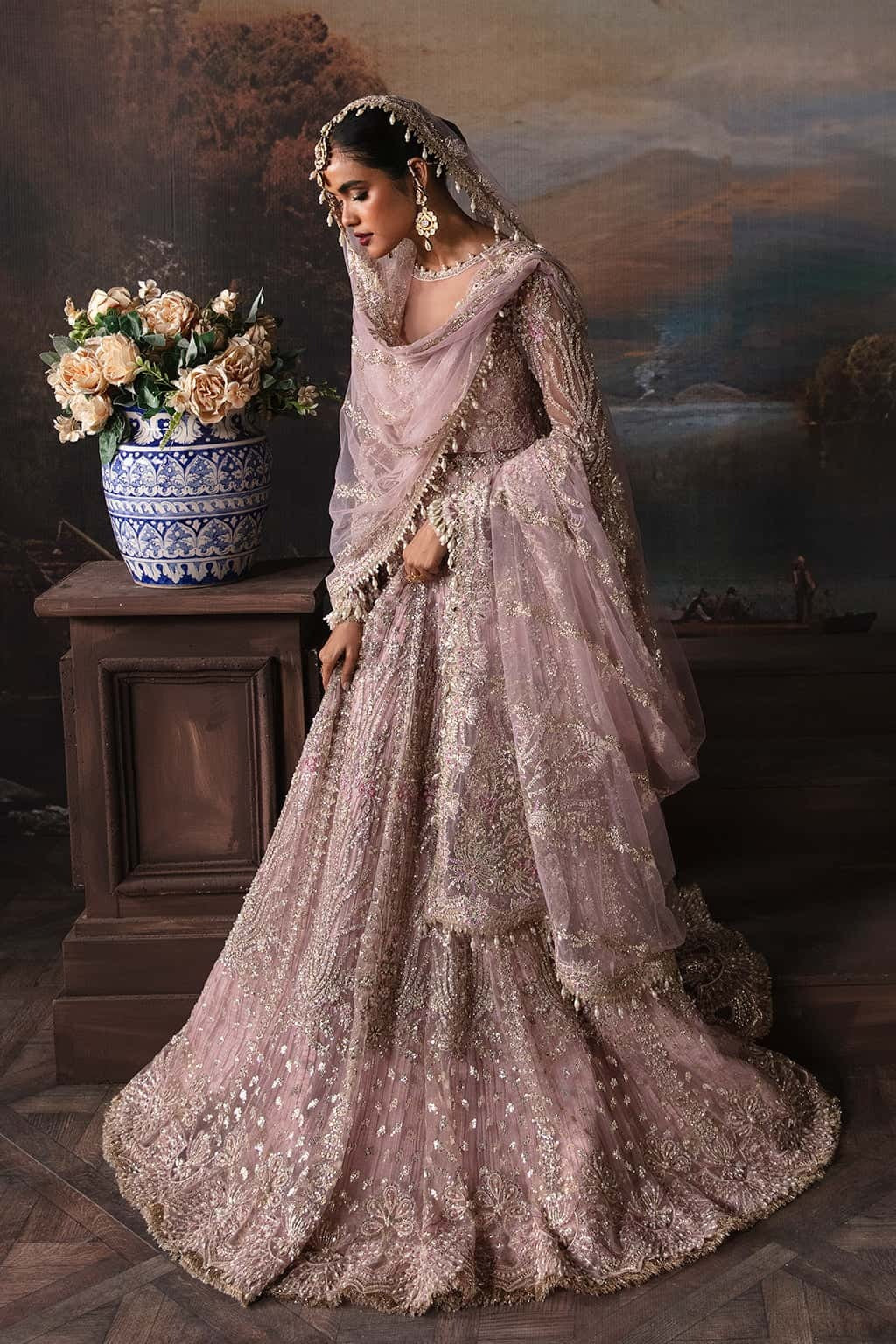 Luxurious net suit with embroidered panels, embellished sleeves, organza dupatta motifs, and raw silk trouser — a perfect festive ensemble.