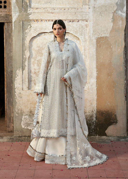 Elegant ivory organza shirt with sequin embroidery, silk sharara, and chiffon dupatta. Unstitched luxury outfit exuding timeless grace and sophistication.