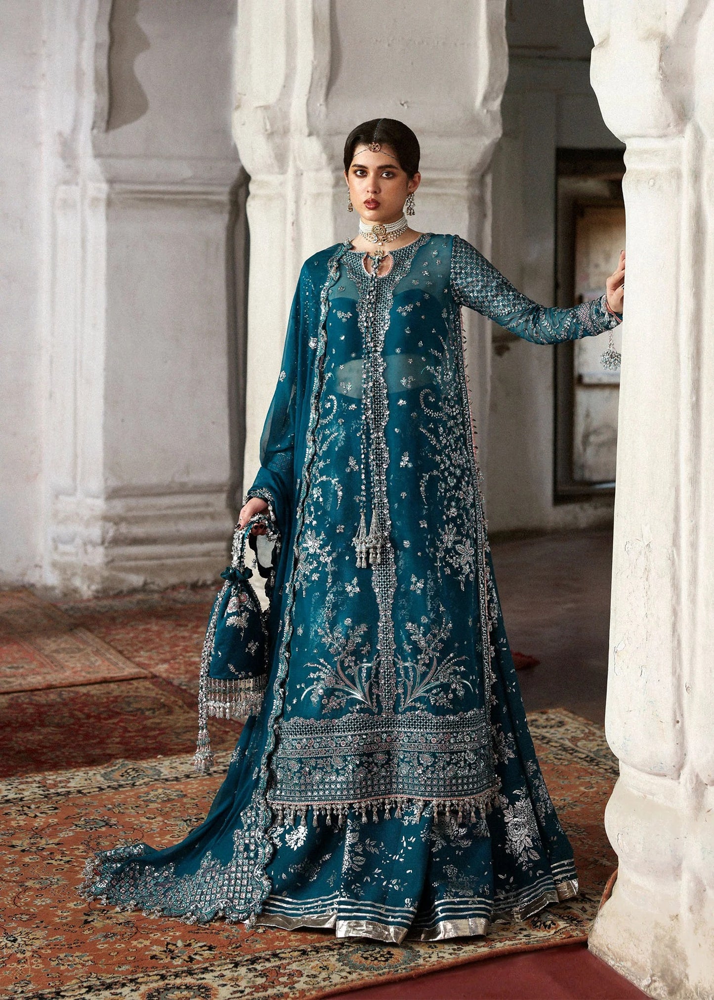 Graceful teal organza shirt with fine embroidery, silk sharara, and chiffon dupatta. Unstitched festive outfit perfect for elegant traditional occasions.