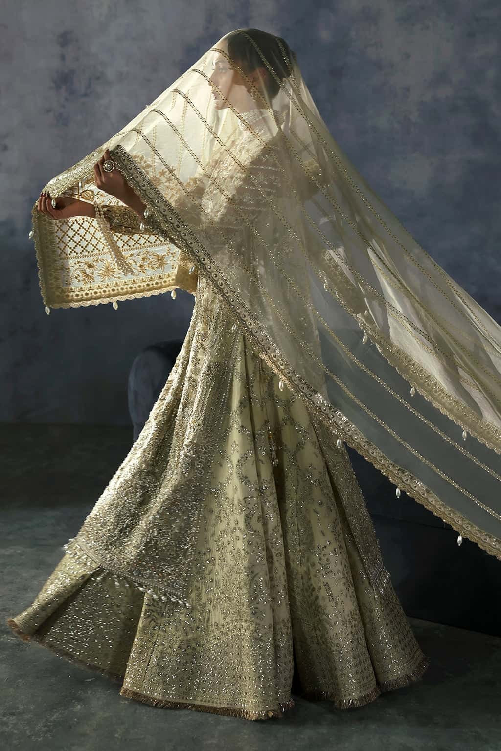 Luxurious organza suit with hand-embellished embroidery, ornate dupatta borders, and embroidered raw silk trouser — perfect for festive elegance.