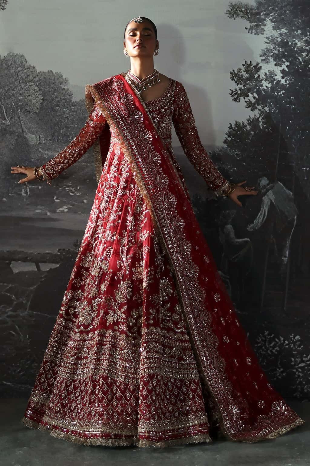 Luxurious net suit with hand-embellished panels, embroidered dupatta with motifs, and raw silk trouser — perfect for weddings and festive wear.