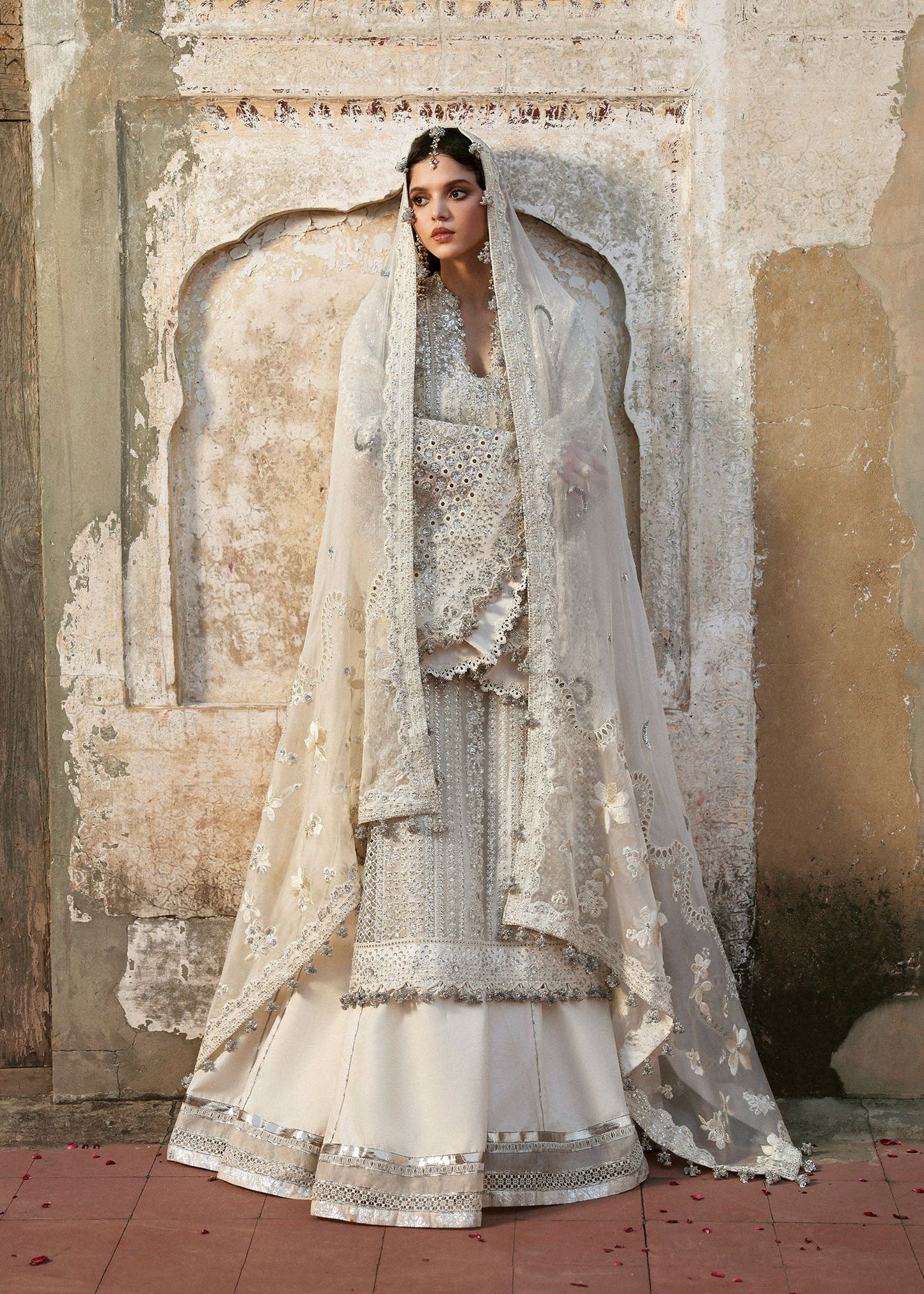 Elegant ivory organza shirt with sequin embroidery, silk sharara, and chiffon dupatta. Unstitched luxury outfit exuding timeless grace and sophistication.